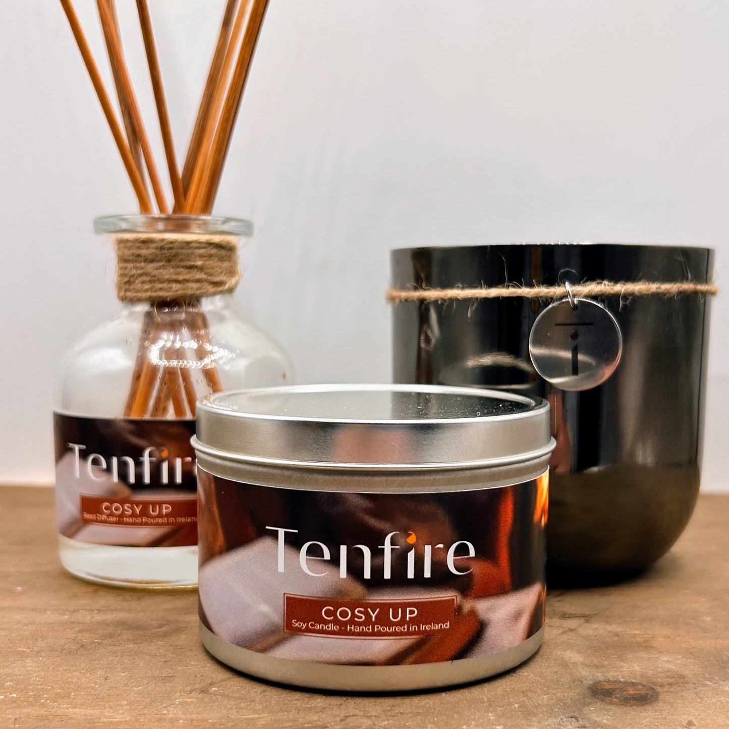 Tenfire candles and diffuser on a wooden surface with a neutral background