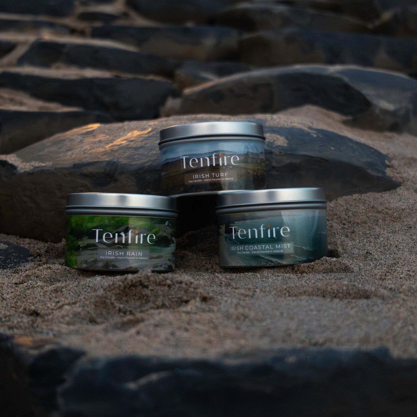 Three Tenfire candles from the Irish Candles Gift Set on a stone surface
