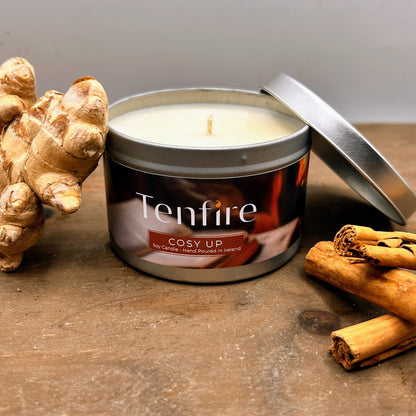 Tenfire candle in a tin with ginger and cinnamon on a wooden surface