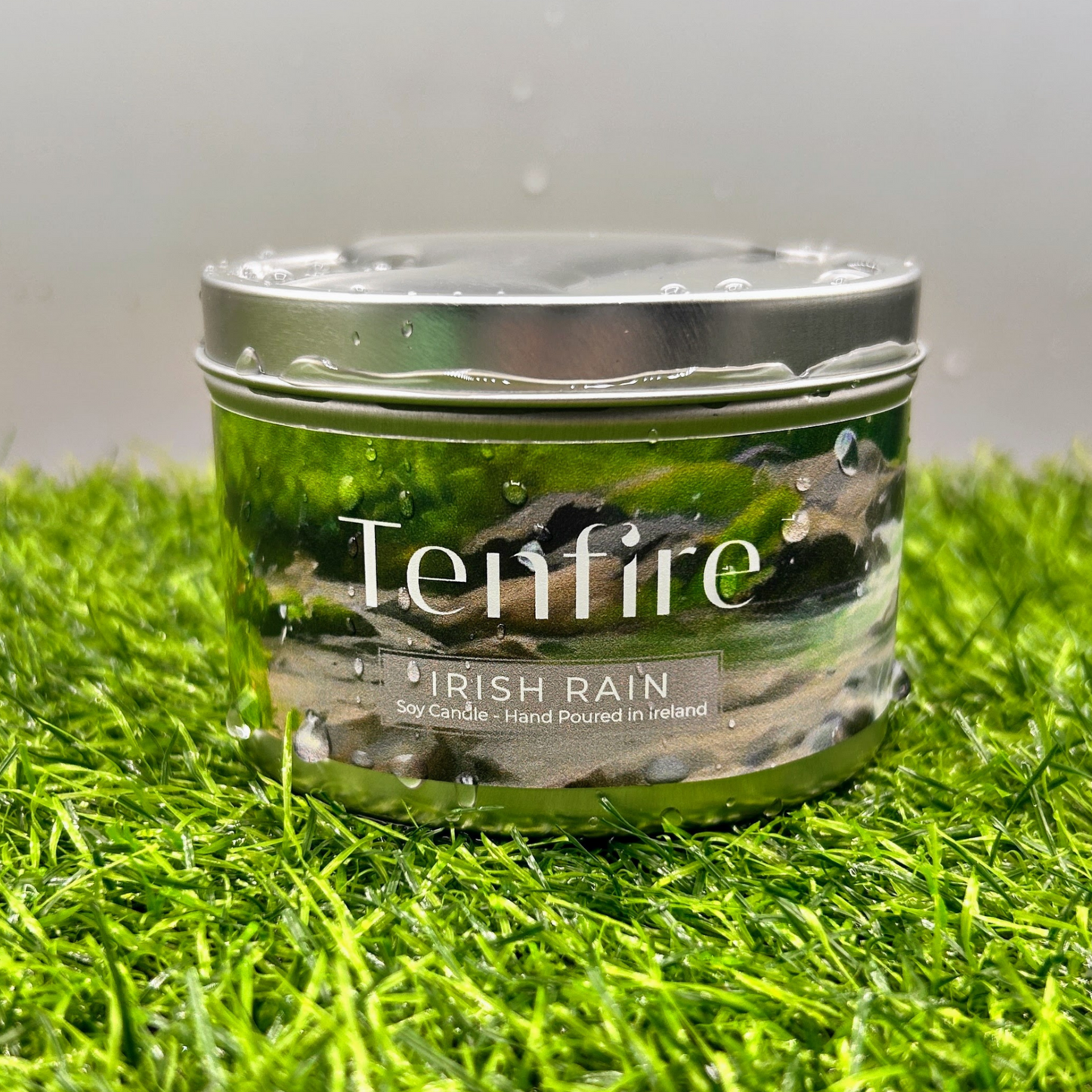 candle tin called irish rain wet with water and sitting on wet grass