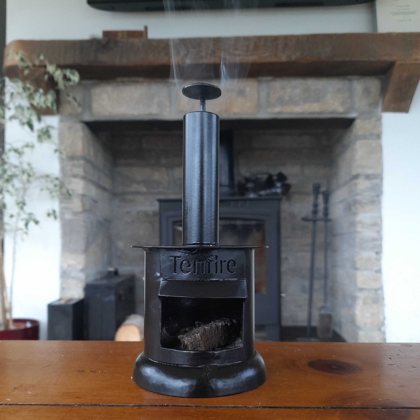 Tenfire stove on a wooden surface with a fireplace in the background